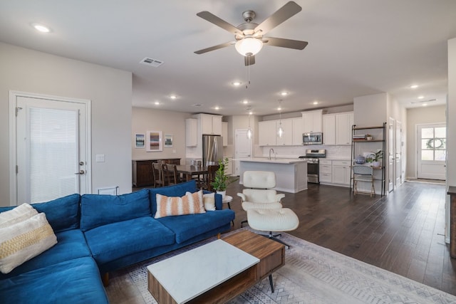 living area featuring a ceiling fan, dark wood finished floors, recessed lighting, and baseboards