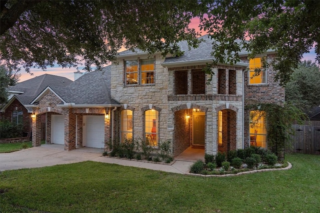 view of front of house with a garage, concrete driveway, a front lawn, and a shingled roof