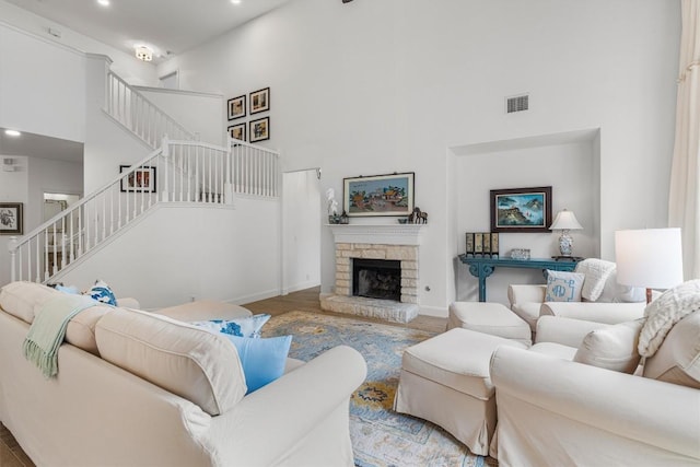 living room featuring baseboards, visible vents, a high ceiling, and stairs