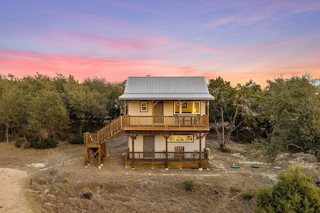 back of house with metal roof and a wooden deck