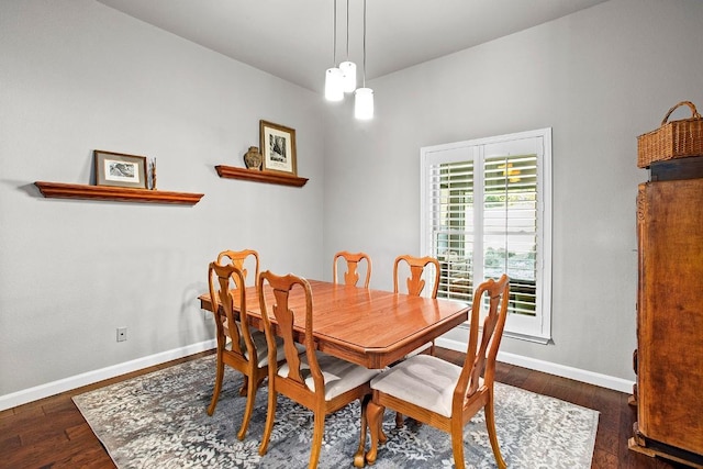 dining space with wood-type flooring and baseboards