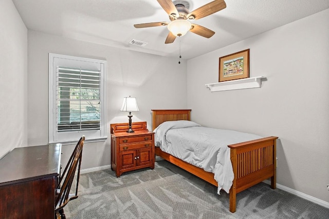 carpeted bedroom featuring a ceiling fan, visible vents, and baseboards