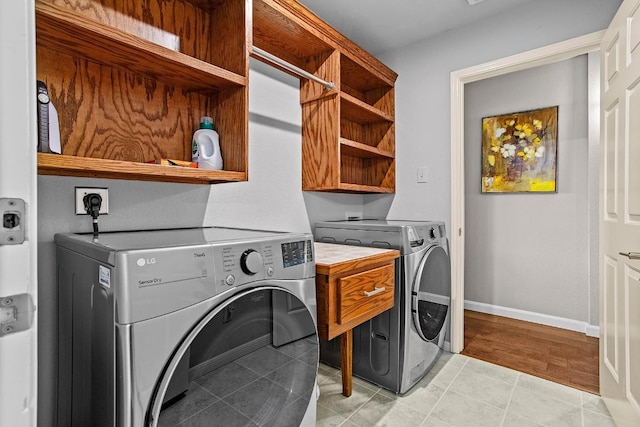 laundry area featuring light tile patterned floors, laundry area, independent washer and dryer, and baseboards