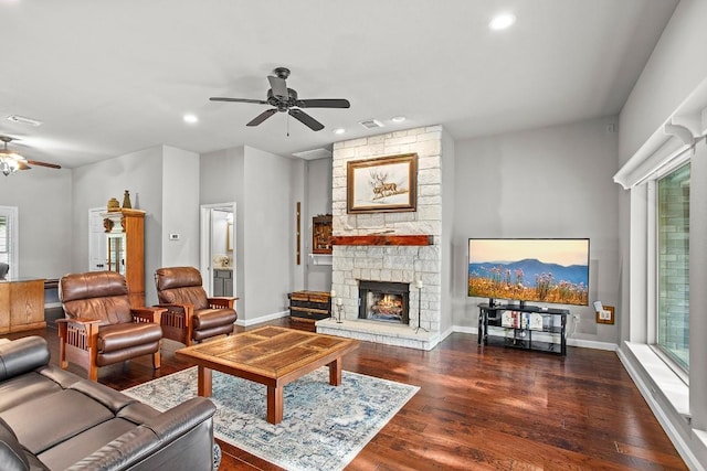 living area featuring recessed lighting, a ceiling fan, a stone fireplace, wood finished floors, and baseboards