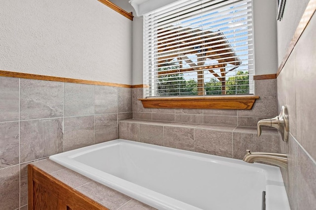 bathroom with a garden tub and tile walls