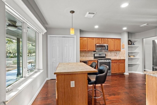 kitchen with visible vents, light countertops, appliances with stainless steel finishes, dark wood-style floors, and tasteful backsplash