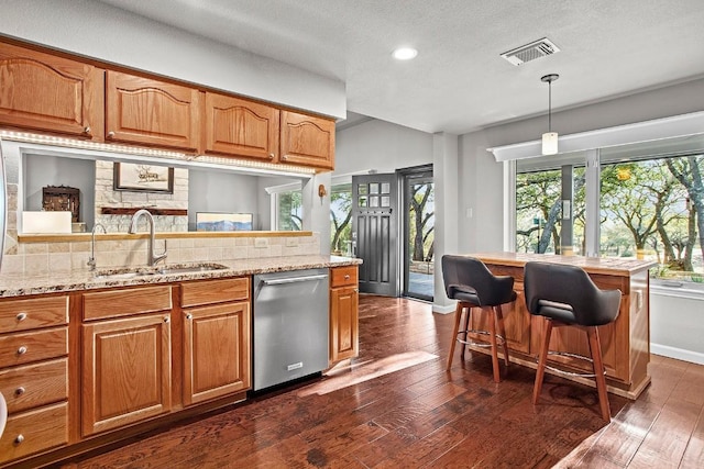 kitchen with a sink, visible vents, dark wood finished floors, and dishwasher