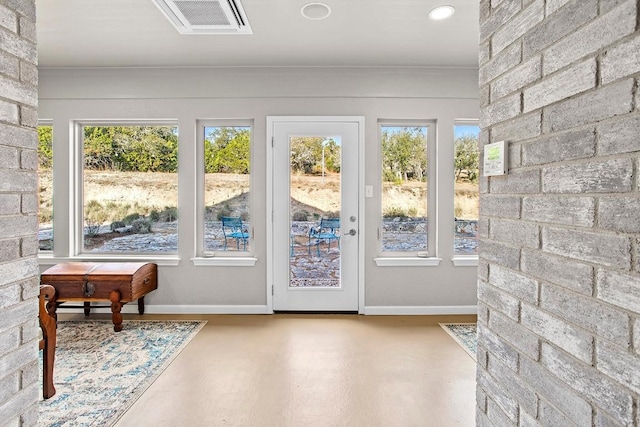 doorway to outside featuring finished concrete flooring and baseboards