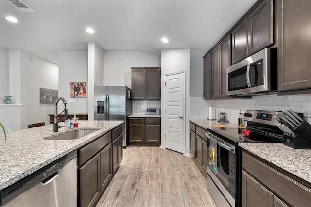 20602 Falcon, Lago Vista, TX 78645 - kitchen with appliances with stainless steel finishes, dark brown cabinetry, tasteful backsplash, light stone countertops, and recessed lighting