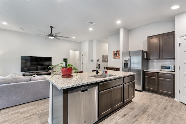 20602 Falcon, Lago Vista, TX 78645 - kitchen featuring appliances with stainless steel finishes, dark brown cabinetry, ceiling fan, open floor plan, and a kitchen island with sink