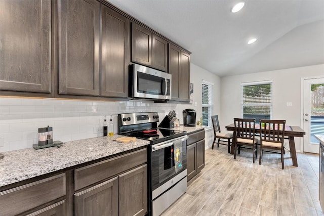 20602 Falcon, Lago Vista, TX 78645 - kitchen with stainless steel appliances, lofted ceiling, dark brown cabinets, tasteful backsplash, and light wood-style flooring