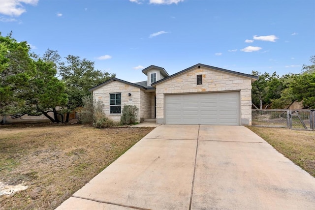 ranch-style home with a garage, concrete driveway, a gate, fence, and a front yard