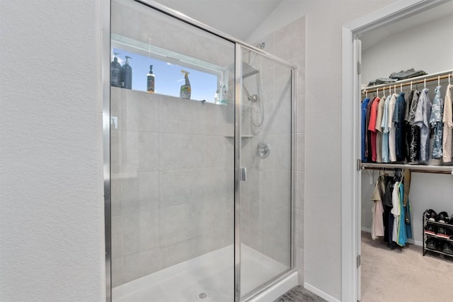 20602 Falcon, Lago Vista, TX 78645 - bathroom with a stall shower, a walk in closet, vaulted ceiling, and a textured wall