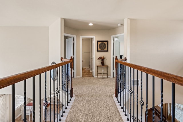 hall with carpet, an upstairs landing, and baseboards