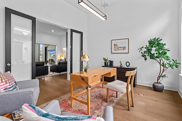 home office with light wood-type flooring and baseboards