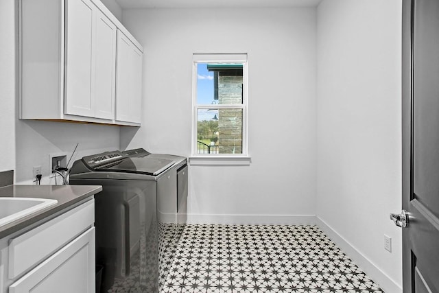 washroom with separate washer and dryer, tile patterned floors, cabinet space, and baseboards