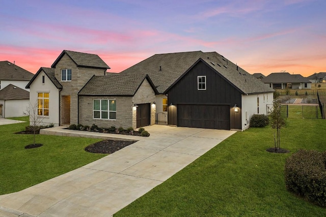 view of front of house with driveway, stone siding, a front lawn, and board and batten siding