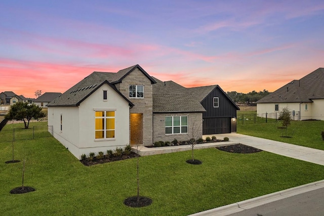 modern farmhouse featuring driveway, fence, and a yard