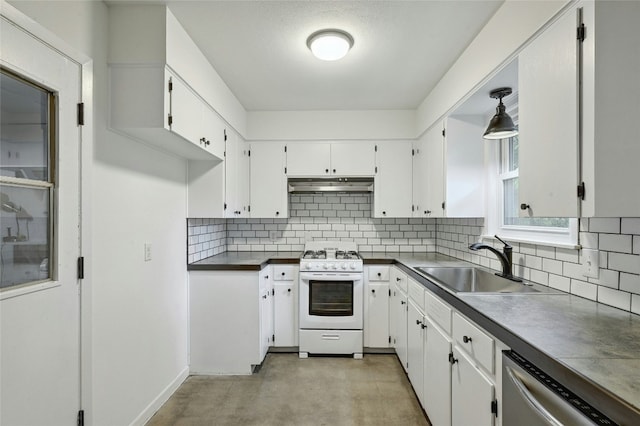 kitchen featuring under cabinet range hood, a sink, stainless steel dishwasher, gas range gas stove, and dark countertops