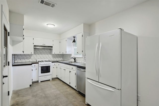 kitchen with under cabinet range hood, white appliances, a sink, visible vents, and dark countertops