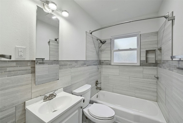 bathroom featuring shower / tub combination, toilet, tile walls, and vanity