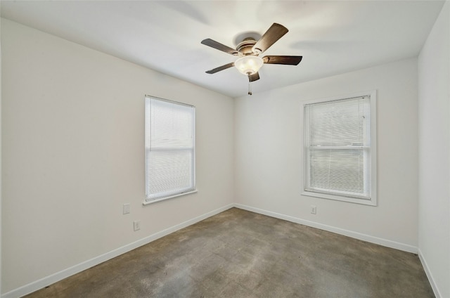 empty room featuring ceiling fan and baseboards