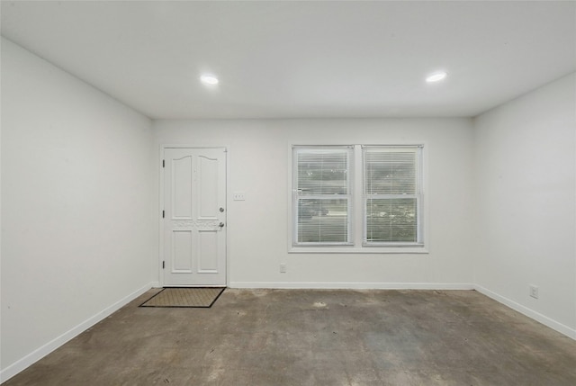 empty room featuring recessed lighting, unfinished concrete flooring, and baseboards