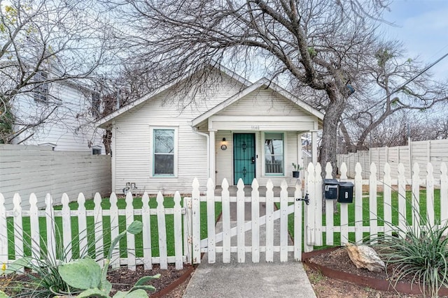 view of front of property with a fenced front yard and a gate