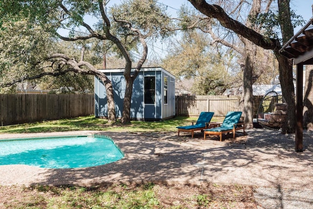 view of swimming pool with a storage shed, an outdoor structure, a fenced backyard, and a fenced in pool