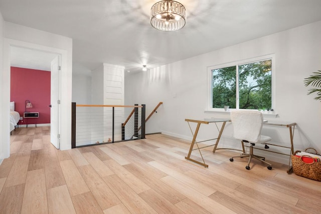 office area with an inviting chandelier, wood finished floors, and baseboards