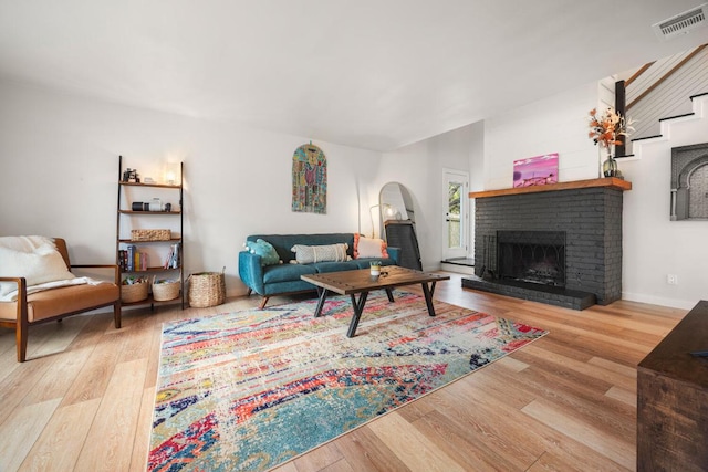 living area featuring a fireplace, wood finished floors, and visible vents