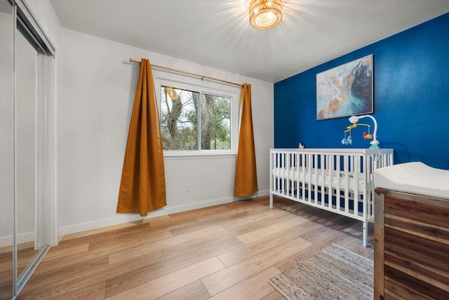 bedroom with a closet, wood finished floors, and baseboards