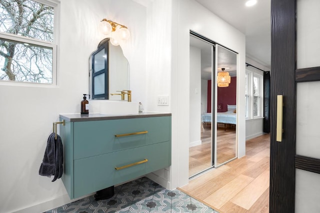 bathroom with baseboards, wood finished floors, and vanity