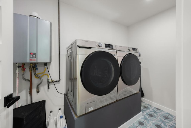 laundry room featuring tankless water heater, laundry area, baseboards, and washing machine and clothes dryer