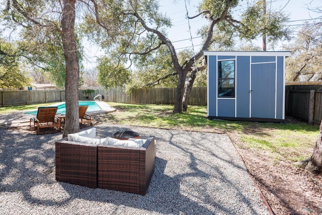 view of yard featuring a fenced in pool, a patio, a storage unit, a fenced backyard, and an outdoor structure