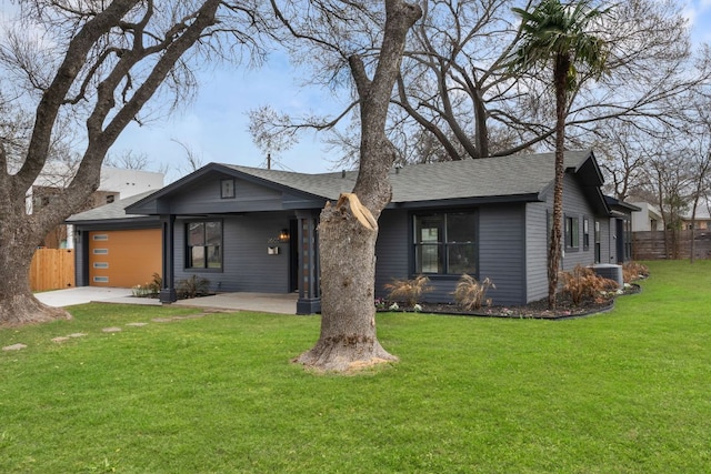 mid-century modern home featuring a garage, a front yard, fence, and driveway