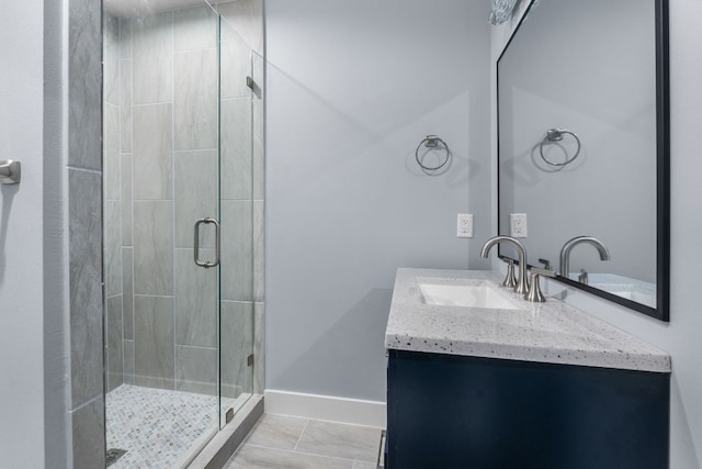 bathroom featuring a stall shower, baseboards, and vanity