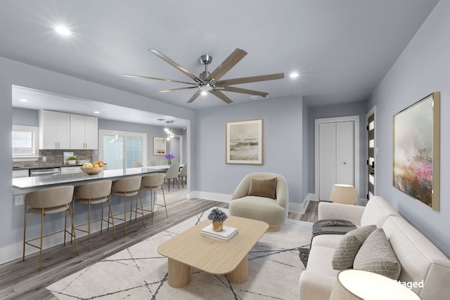 living area with a ceiling fan, light wood-type flooring, baseboards, and recessed lighting