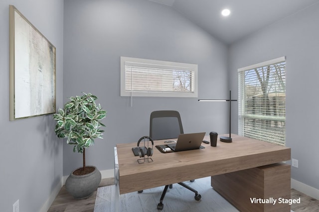 office space featuring vaulted ceiling, baseboards, and wood finished floors