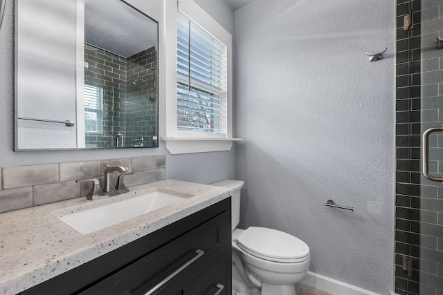 full bathroom featuring toilet, a textured wall, tiled shower, and vanity