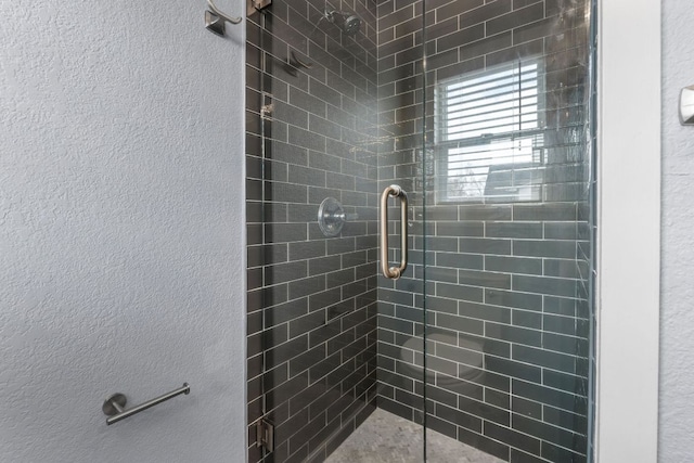 bathroom featuring a stall shower and a textured wall