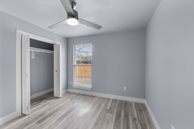 unfurnished bedroom featuring a ceiling fan, a closet, light wood-style flooring, and baseboards