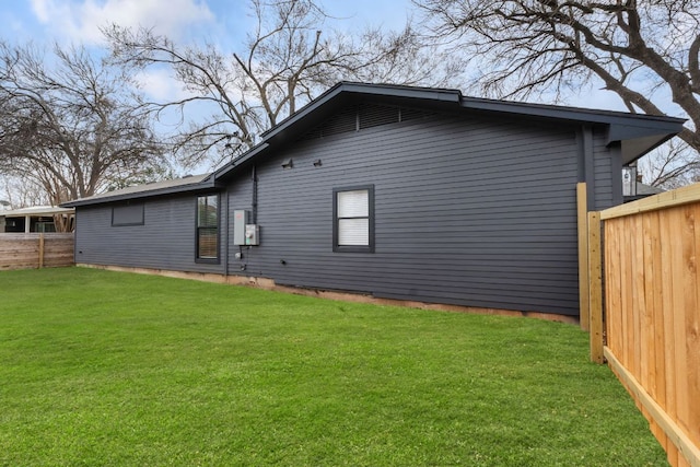 rear view of house featuring a fenced backyard and a lawn