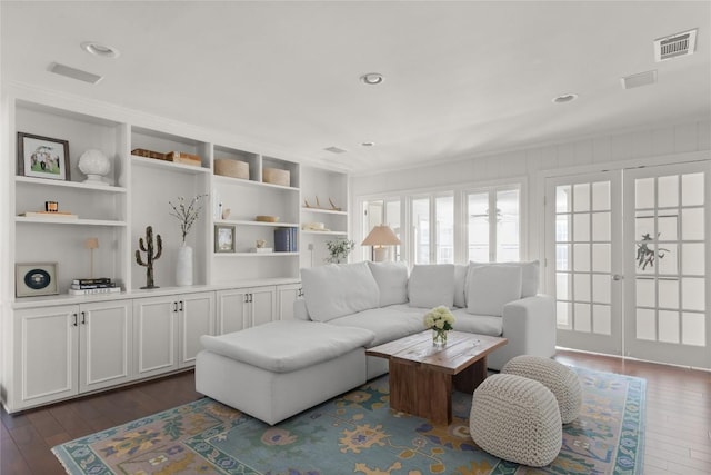 living room with french doors, dark wood finished floors, visible vents, and built in features