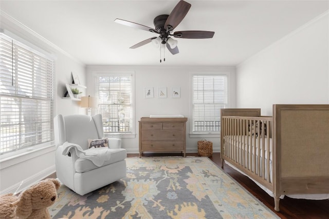 bedroom with ceiling fan, ornamental molding, wood finished floors, and baseboards