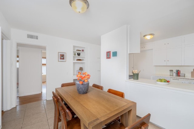 dining area with built in shelves, visible vents, and light tile patterned floors