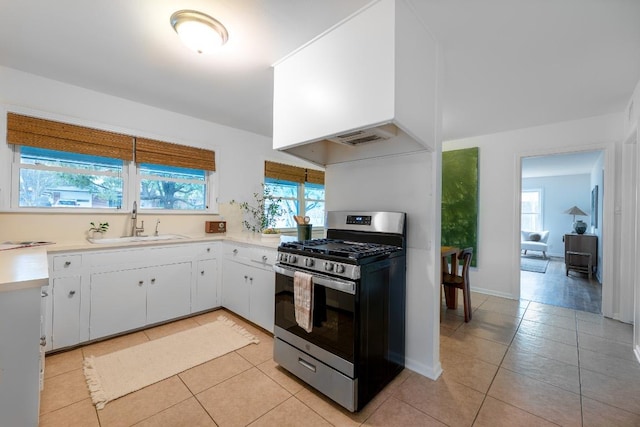 kitchen featuring a sink, a healthy amount of sunlight, light countertops, and stainless steel range with gas stovetop