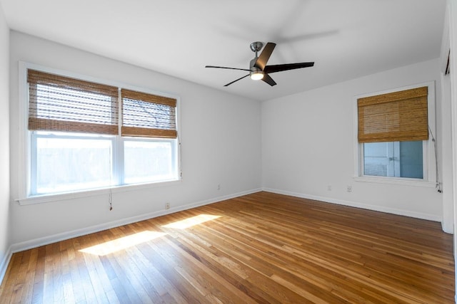 empty room with baseboards, ceiling fan, and hardwood / wood-style floors