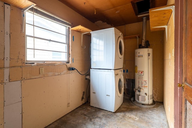 washroom featuring gas water heater, stacked washing maching and dryer, and laundry area