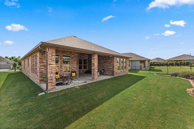 back of house featuring a patio, brick siding, fence, a yard, and roof with shingles